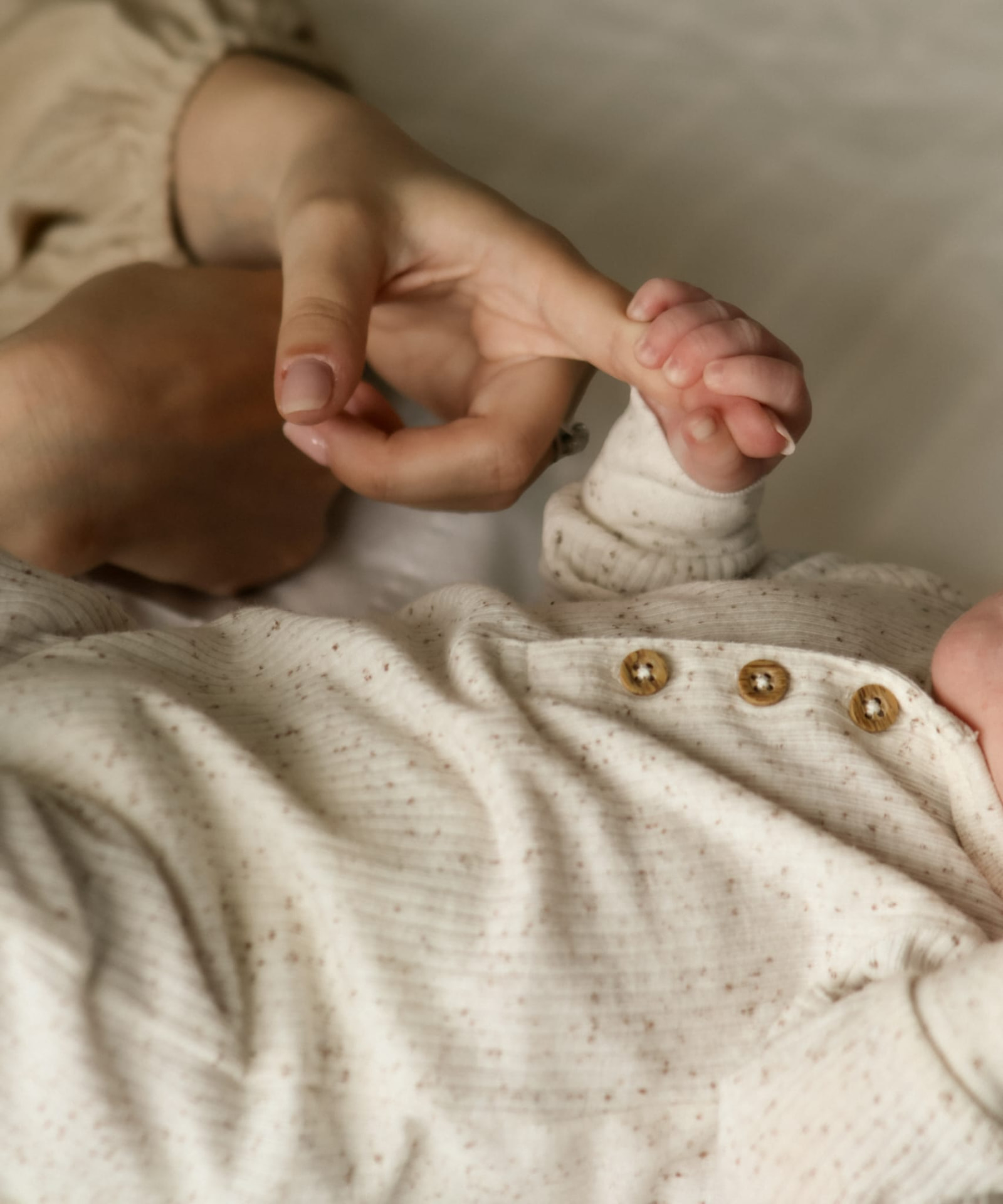 Close up of a mother holding her newborn's tiny hand