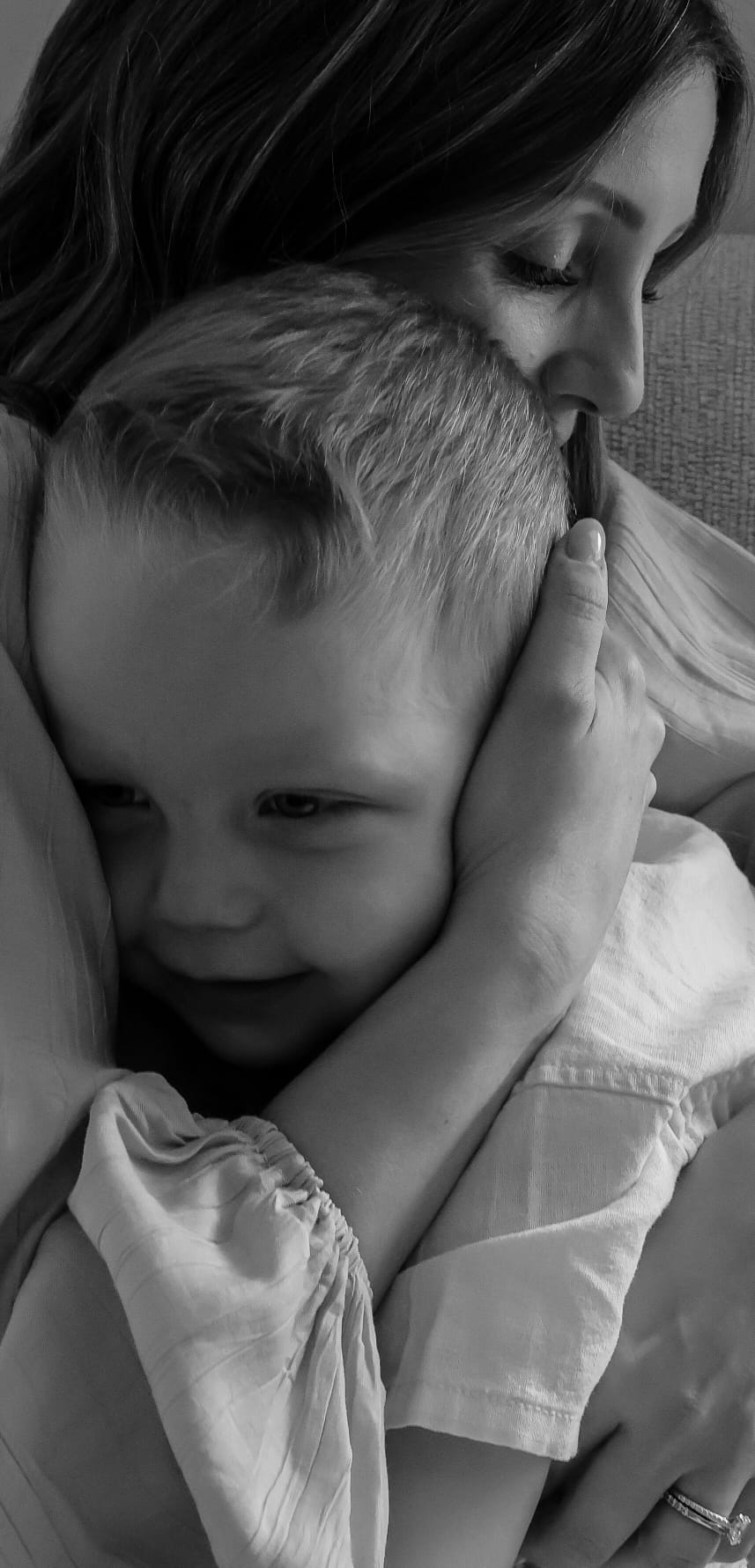 Black and white portrait of a mother holding her young son close