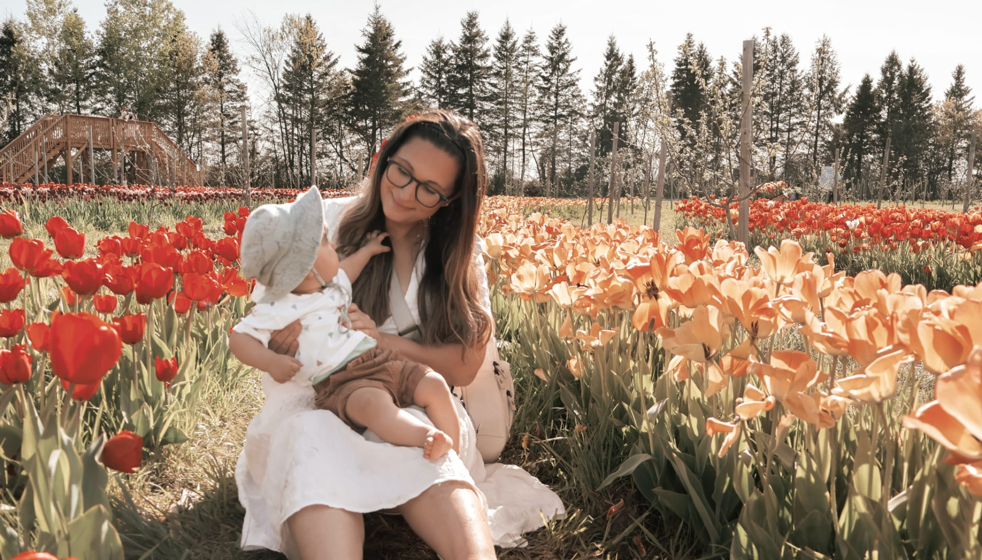 Anela holding her baby among colorful tulip fields
